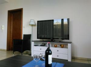 Una botella de vino sobre una mesa con dos copas de vino. en ApartamentyPrzyMorzu Olympic Park z Prywatnym Tarasem z Widokiem Na Morze, en Kołobrzeg
