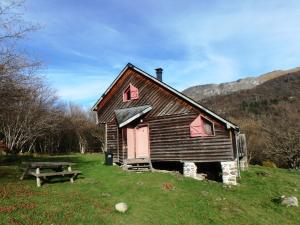 an old cabin with a picnic table in a field at Les chalets de la forêt d'Issaux in Osse-en-Aspe