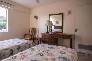 a bedroom with two beds and a mirror at Sunset Two Bedroom Suite At Turtle Towers in Ocho Rios