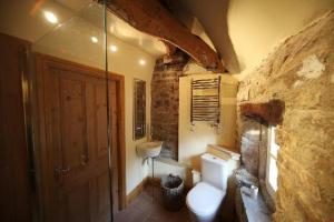 uma casa de banho em pedra com um WC e um lavatório em The Rake Tapas Accommodation em Littleborough