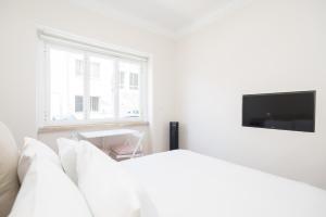 リスボンにあるRiverside Charming Studio in Belémの白いベッドルーム(ベッド1台、薄型テレビ付)