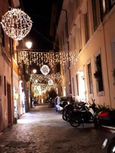 eine Gasse mit Weihnachtslichtern und Motorrädern auf einer Straße in der Unterkunft Marina in Rom