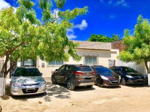 a group of parked cars parked in front of a house at Ótima Localização casa, 7 quartos-Porto de Galinhas 900m piscinas naturais in Porto De Galinhas