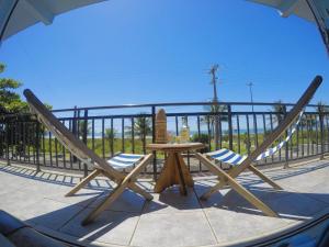 a table and chairs on a balcony with the ocean at Apto Frente para o Mar in Pontal do Paraná