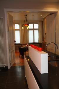 - une cuisine avec un comptoir orné de roses rouges dans l'établissement B&B @ Room's, à Ypres