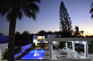 a house with a swimming pool and a palm tree at Eco Bay Hotel in Bahía Kino