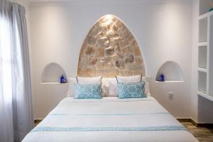 a bedroom with a large bed with a stone wall at Hotel Abaco Altea in Altea