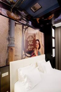 Una mujer está de pie detrás de una cama en una habitación en Hotel Fabrica do Chocolate, en Viana do Castelo