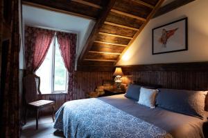 una camera da letto con un letto, una sedia e una finestra di Auberge Restaurant La Mara a Saint-Joseph-de-Ham-Sud