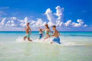 un grupo de personas jugando en el agua en la playa en Sandos Playacar All Inclusive, en Playa del Carmen