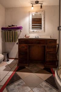 un bagno con lavandino, WC e specchio di Auberge Restaurant La Mara a Saint-Joseph-de-Ham-Sud Altre 30 foto