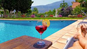 a glass of wine sitting on a table next to a pool at Villa Adelaida in Órgiva