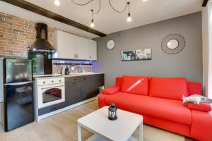 salon z czerwoną kanapą i kuchnią w obiekcie Appart-hôtel64 Bayonne w Bajonnie