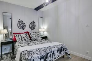 sypialnia z łóżkiem z czarno-białą kołdrą w obiekcie Appart-hôtel64 Bayonne w Bajonnie