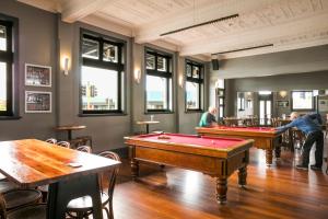 two pool tables in a room with people playing at Nightcap at the Ship Inn in Busselton