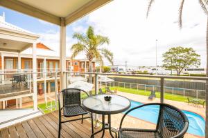 a balcony with a table and chairs and a pool at Nightcap at the Ship Inn in Busselton