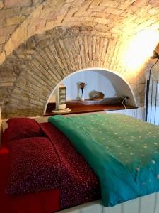 łóżko w pokoju z kamienną ścianą w obiekcie Royal Holiday House at the center w Rzymie