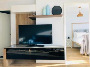 uma sala de estar com uma grande televisão sobre uma mesa em Staying Places - The Avenue em Camberra