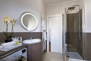 a bathroom with a sink and a shower with a mirror at LaGare in Neive