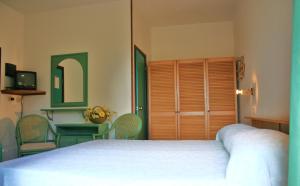 a bedroom with a bed and a table and chairs at Hotel Maristella in Cavo