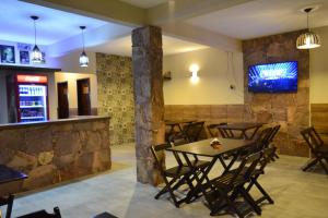 a restaurant with tables and chairs and a tv on the wall at Pousada Guiné in Mucugê