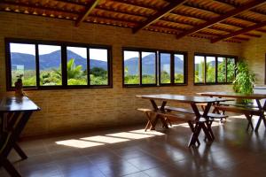 two picnic tables in a room with windows at Pousada Guiné in Mucugê