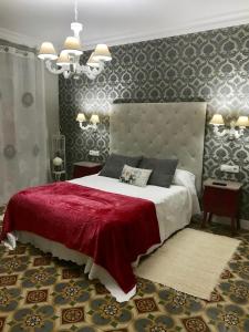 アレーナス・デ・サン・ペドロにあるCharcos de Gredosのベッドルーム1室(赤いベッドカバー付きの大型ベッド1台付)