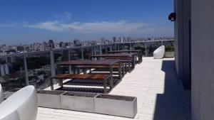 una fila de mesas y bancos en un balcón en Mirador 1205 en Buenos Aires