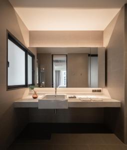 T2 Residence Sathorn في بانكوك: حمام مع حوض ومرآة كبيرة