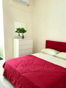 a bedroom with a red bed and a white dresser at Sisikami Guesthouse in Changlun