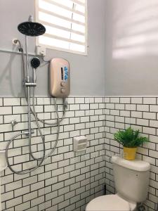 a shower in a white bathroom with a toilet at Sisikami Guesthouse in Changlun +8 photos