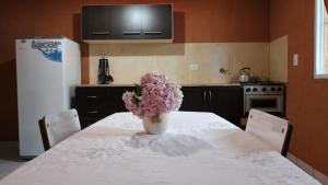 una cocina con una mesa con un jarrón de flores. en El Huerto Departamentos - Villa Carlos Paz en Villa Carlos Paz