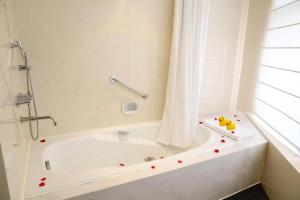 a bathroom with a bath tub with a shower and a tub at Jianguo Hotel Guangzhou in Guangzhou