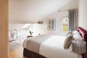 Un dormitorio blanco con una cama grande y una mesa en Box Art Hotel - La Torre, en Collado Mediano 37 fotos más