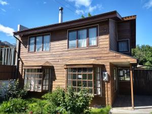 a wooden house with a black roof at Patagon Backpackers in Coihaique