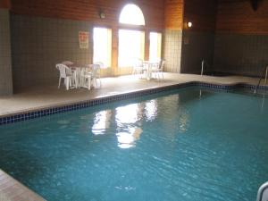a swimming pool with tables and chairs in a building at Knights Inn Litchfield in Litchfield
