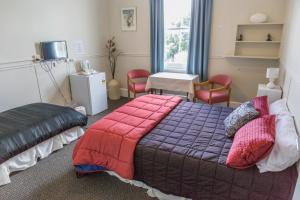 1 dormitorio con 1 cama, mesa y sillas en Post Office Hotel, en Foxton