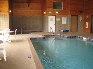 a swimming pool in a building with a table and chairs at Knights Inn Litchfield in Litchfield