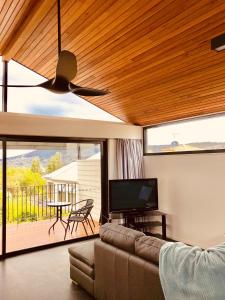 a living room with a couch and a ceiling fan at Omaroo House - panoramic water views in Hobart