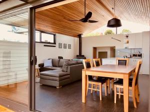 cocina y sala de estar con mesa y sofá en Omaroo House - panoramic water views en Hobart