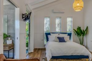 a bedroom with a blue and white bed and windows at Hampton Estate Wines in Mount Tamborine +24 photos