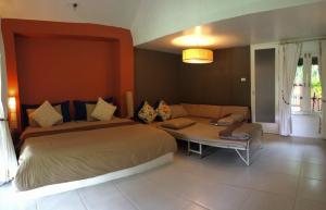een slaapkamer met een groot bed en een bank bij Phayam Cottage Resort in Ko Phayam