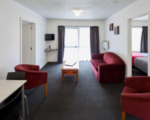 a hotel room with a couch and chairs and a table at Aotea Motel in Christchurch