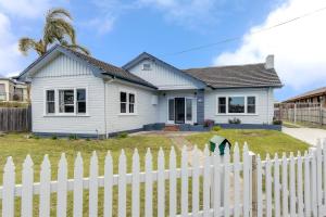 a white picket fence in front of a white house at Seashells Lakes Entrance in Lakes Entrance