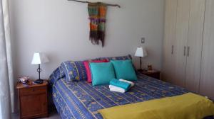 Un dormitorio con una cama con almohadas de colores. en depto nuevo temuco, en Temuco