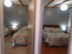 a bedroom with two beds and two lamps and a doorway at Departamento Luna Andina in San Pedro de Atacama