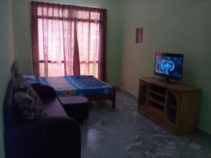 a living room with a tv and a couch at Haji Din Cocobay Condo in Port Dickson