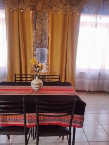 a dining room table with a vase on top of it at Departamento Luna Andina in San Pedro de Atacama +13 photos