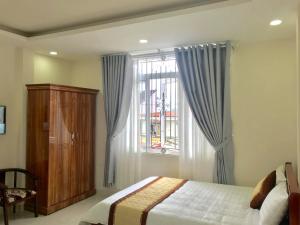 大叻的住宿－Mai Ngoc Hotel，一间卧室设有一张床和一个窗口