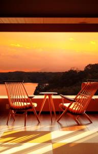 2 Stühle und ein Tisch auf dem Balkon in der Unterkunft Kikusuitei in Tokorozawa